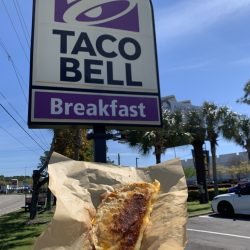 taco in front of Taco Bell sign
